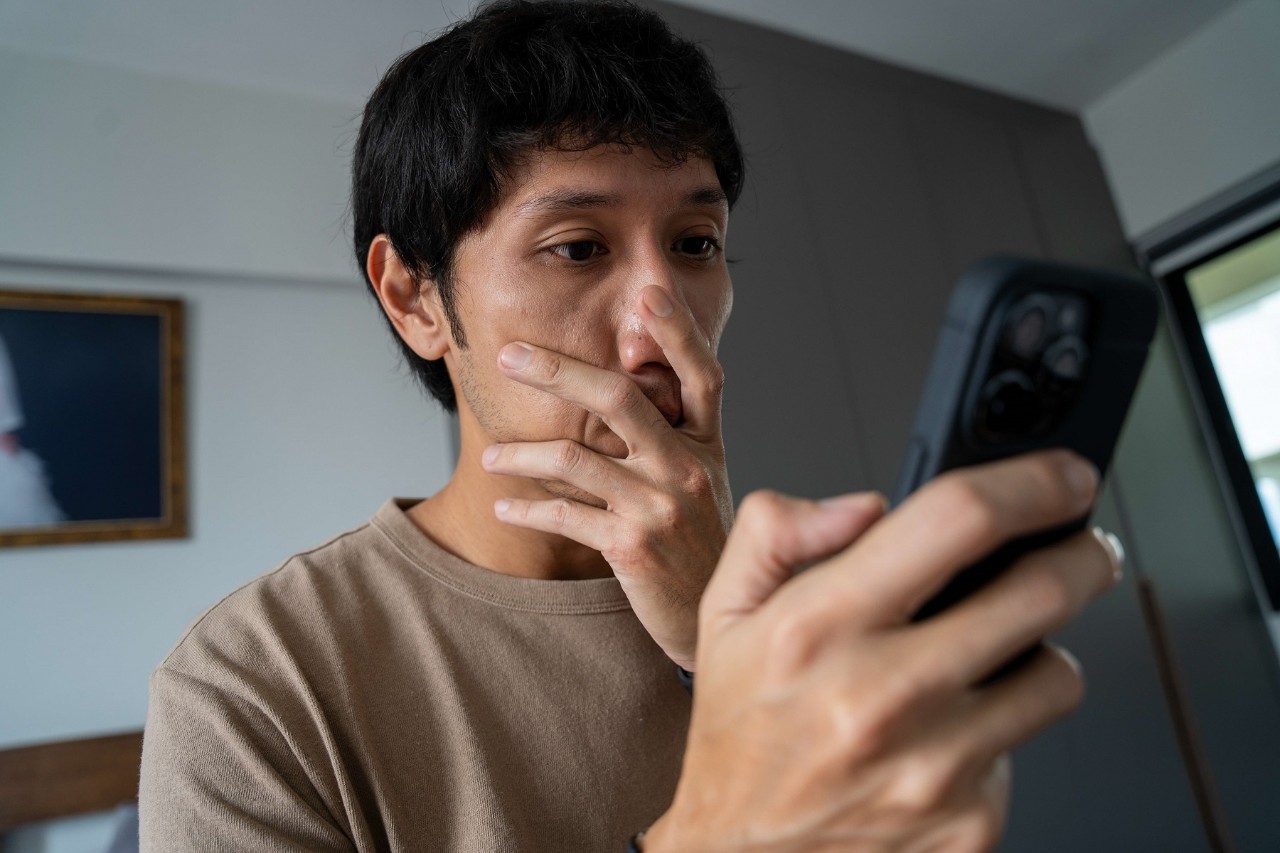 man shocked while looking at his phone